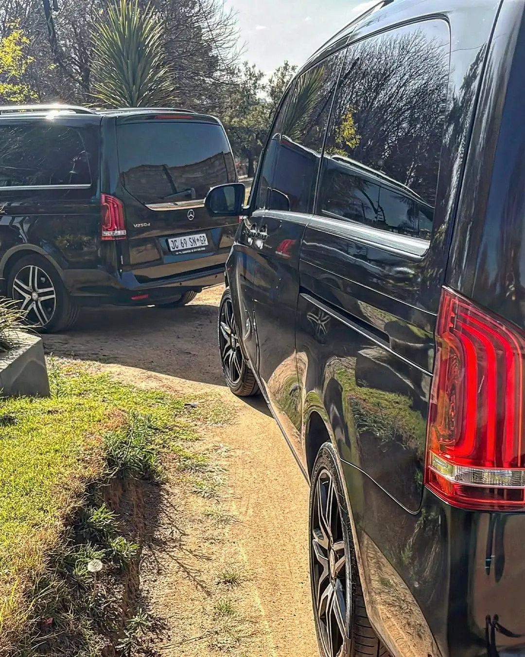 Two black Mercedes V-Class vans parked side by side