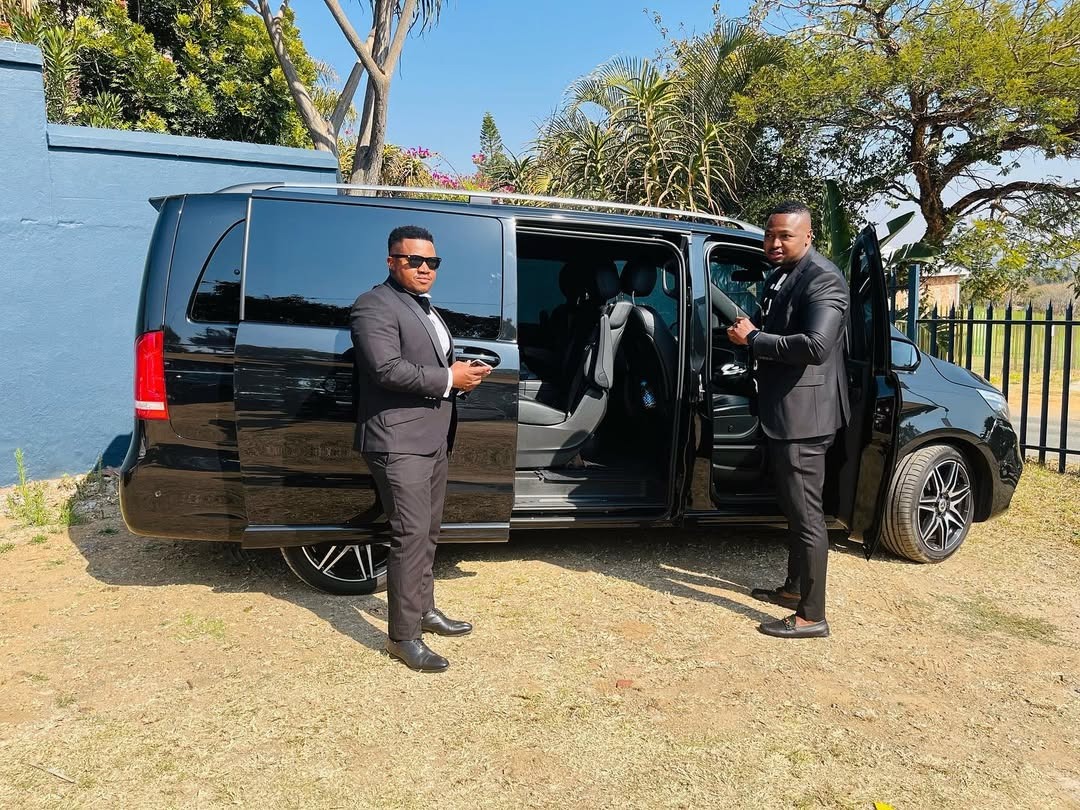 Suited chauffeurs beside a black V-Class